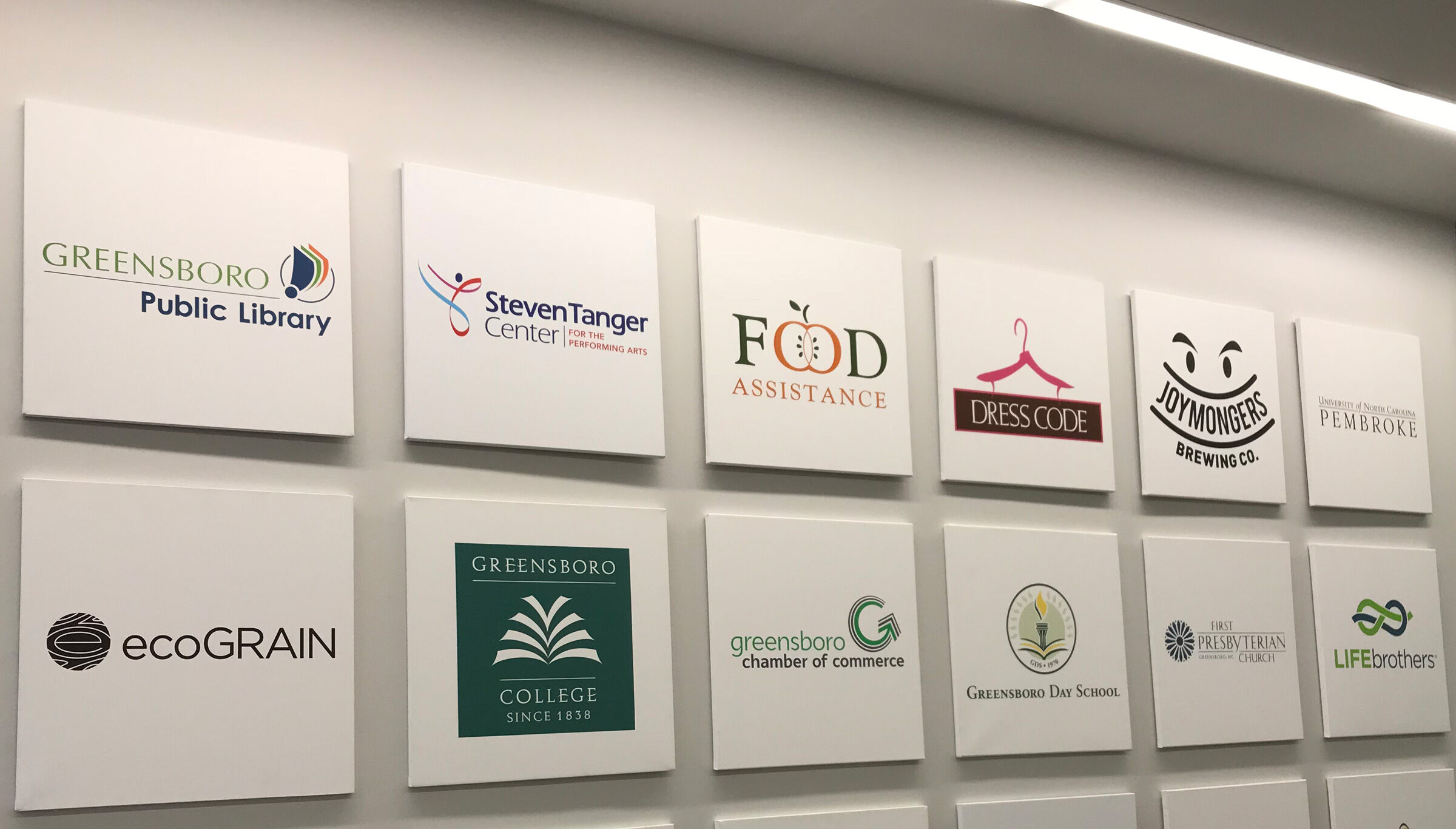 Wall featuring prints of various logos designed by Boulton Creative